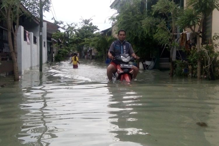 Seorang warga Desa Sriwulan,  Kecamatan Sayung,  Kabupaten Demak,  Jateng,   nekat menerjang banjir rob yang melanda kampungnya,  Jumat (1/12/2017)