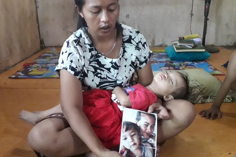 Leha menunjukkan potret salah satu anaknya yang meninggal setelah tanpa sengaja terkurung seharian dalam sebuah mobil pada akhir pekan lalu. Foto diambil di rumah Leha di Penjaringan, Jakarta Utara, Senin (22/10/2018) kemarin.