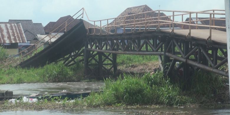 Inilah jembatan yang ambruk akibat desakan berton-ton rumput yang hanyut di bawah arus sungai lalu tersangkut di tiang jembatan. Jembatan yang ambruk adalah penghubung Desa Cinta Jaya dengan sejumlah desa lainnya di Kecamatan Pedamaran, OKI.