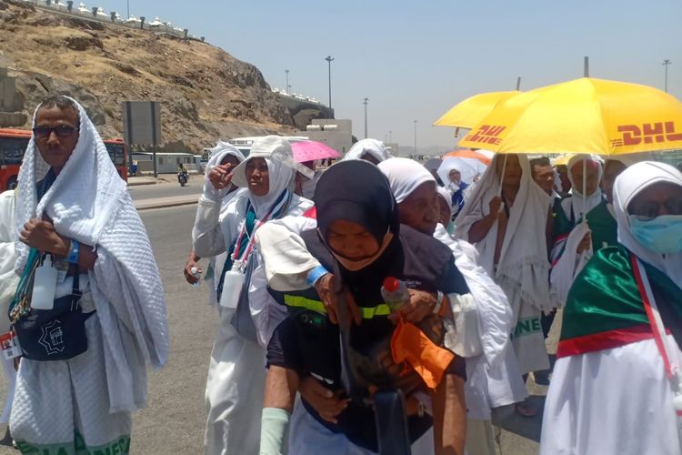 Petugas haji 2023, Nur Istibsaroh saat menggendong jemaah lansia yang kelelahan di Mina, Arab Saudi. 