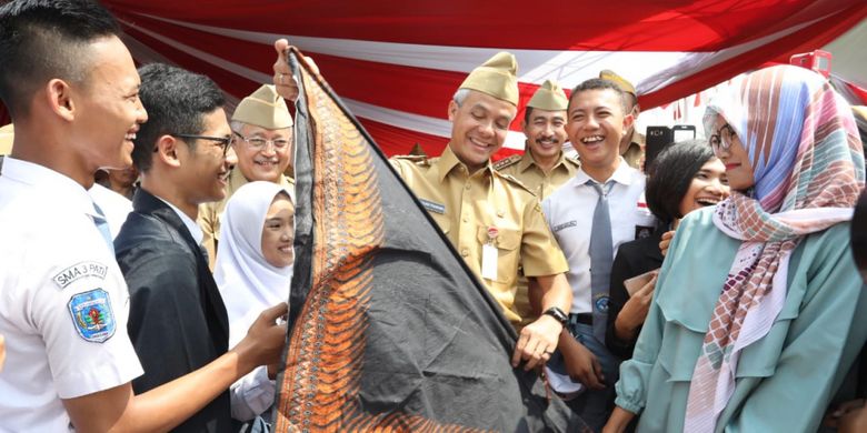 Gubernur Jawa Tengah Ganjar Pranowo menerima kado ulang tahun dari siswa SMA pada peringatan Hari Sumpah Pemuda di Alun-alun Kabupaten Pati, Minggu (28/10/2018)