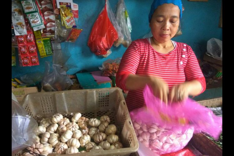 Ibu Jejen pedagang sayur di Sukamaju Baru, Cimanggis Depok sedang membersihkan bawang putih, Rabu (14/2/2018).