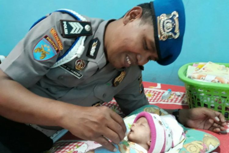 Brigadir Nur Ali Suwandi saat memberikan susu kepada bayi yang diasuhnya, Muhammad Tito Karnavian.