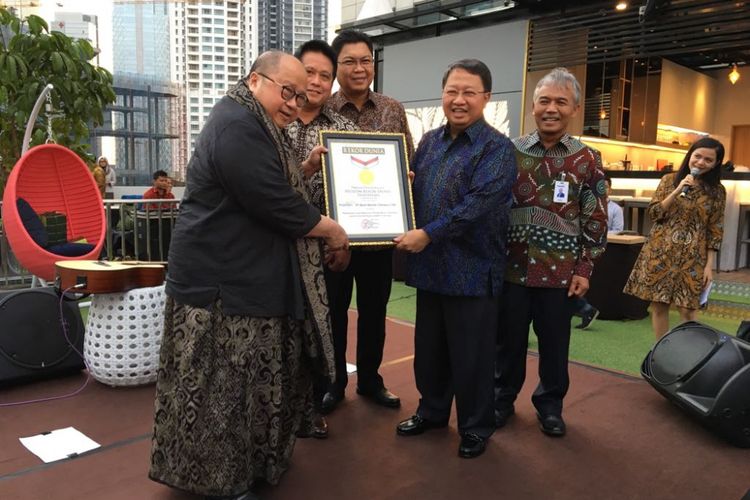 Pendiri Museum Rekor Dunia Indonesia (MURI) Jaya Suprana menyerahkan piagam penghargaan kepada PT Bank Mandiri (Persero) Tbk yang meraih rekor dunia untuk pelaksanaan gerai produk ritel perbankan secara serentak. Penghargaan diberikan di Plaza Mandiri, Kamis (24/5/2018).