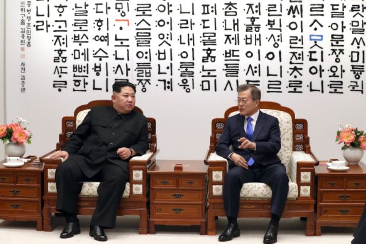 Pemimpin Korea Utara Kim Jong Un (kiri) ketika berbicara dengan Presiden Korea Selatan Moon Jae In saat Konferensi Tingkat Tinggi di Panmunjom Jumat (27/4/2018).