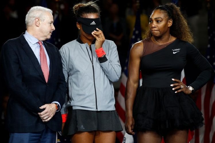 Petenis Jepang, Naomi Osaka (menutup muka dengan topi), setelah memenangi pertandingan final melawan petenis AS, Serena Williams, pada Minggu (9/9/2018).