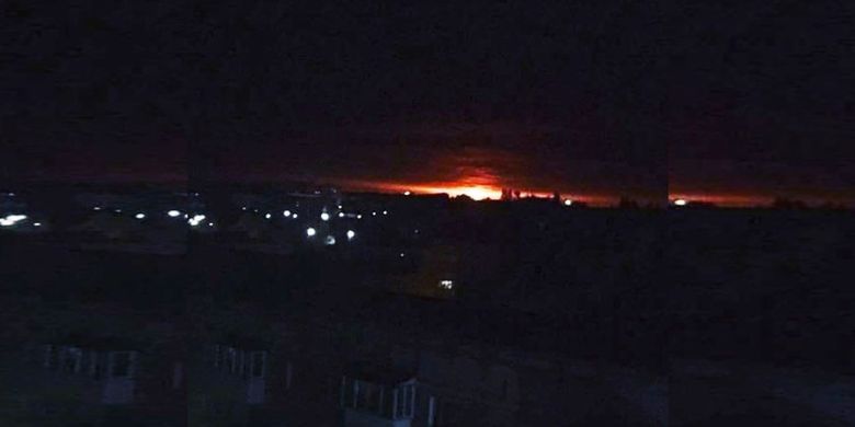 Cahaya terlihat dari sebuah gudang senjata di Ichnia, Ukraina, yang dilaporkan meledak dan terbakar Selasa dini hari (9/10/2018).