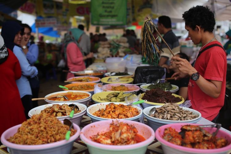 Pedagang takjil menjajakan dagangannya berupa hidangan untuk berbuka puasa di lahan kosong sebelah tempat penampungan sementara Pasar Bendungan Hilir (Benhil), Jakarta, Senin (5/6/2017). Pasar Ramadhan ini mulai buka sekitar pukul 11.00 sampai dengan buka puasa.