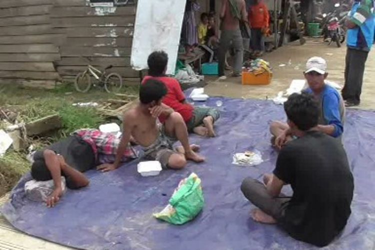 Stres dan bingung mencari tempat pengungsian karena rumahnya hanyut terseret banjir, korban banjir bandang di Kota Mamuju, Sulawesi Barat terpaksa tidur di pinggir jalan sambil menghamparkan terpal plastik.