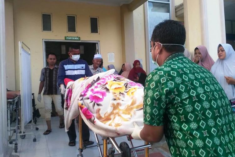 Petugas membawa jenazah Irawati, korban pembunuhan ke Puskemas Muara Batu, Aceh Utara, Selasa (7/5/2019)