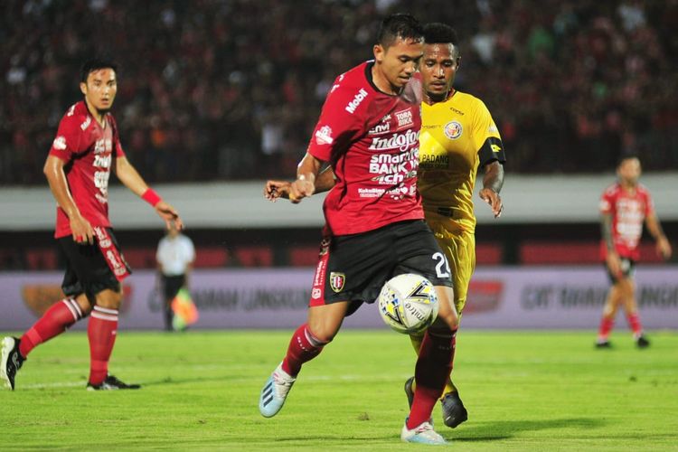 Bek Bali United, Ricky Fajrin, dikawal pemain Semen Padang di Stadion I Wayan Kapten Dipta, Jumat (9/8/2019).