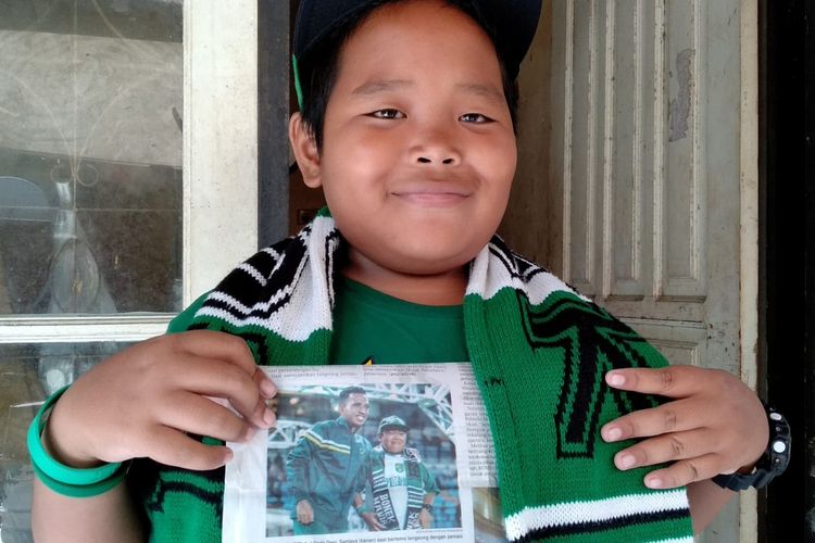Deni memperlihatkan fotonya bersama pemain Persebaya Surabaya Irfan Jaya yang terpampang di salah satu media cetak.