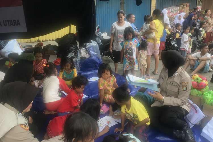 Sejumlah Polisi Wanita (Polwan) menghibur anak-anak korban pengungsian di Kampung Bandan, Ancol, Padamangan, Jakarta Utara Selasa (14/5/2019). 