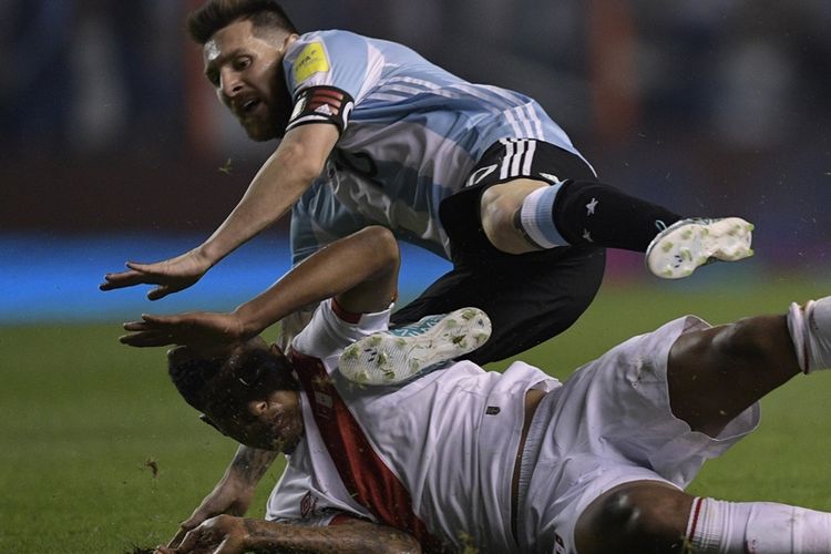 Penyerang Argentina, Lionel Messi (atas) dan pemain Peru, Wilder Cartagena, beradu fisik dalam pertandingan Kualifikasi Piala Dunia 2018 zona Amerika Selatan di Buenos Aires, Argentina, 5 Oktober 2017.
