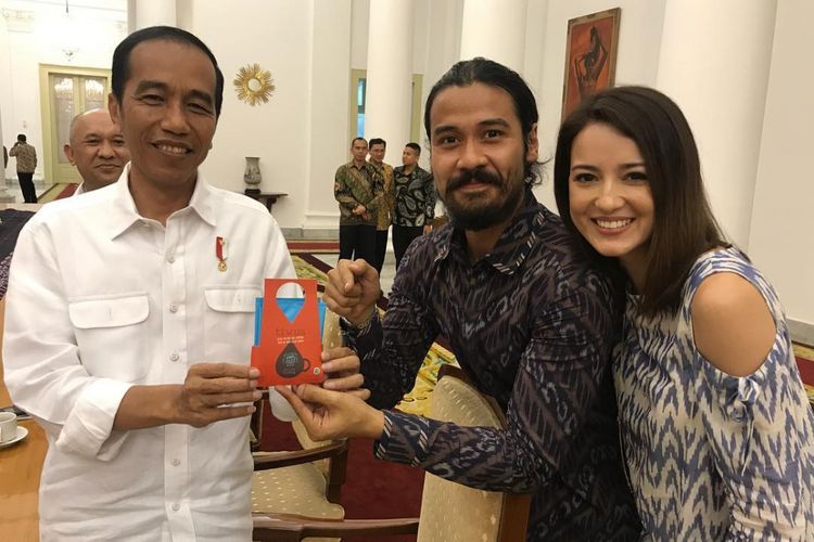 Artis peran Chicco Jerikho memberikan biji kopi Tiwus kepada Presiden Joko Widodo pada peringatan Hari Kopi Internasional di Istana Bogor, Minggu (1/10/2017). Pesohor lain yang hadir dalam acara itu ada artis peran Julie Estelle (kanan) dan penulis Dee Lestari.