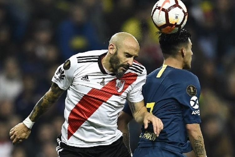 Javier Pinola dan Cristian Pavon tampak berduel di udara pada laga final Copa Libertadores antara River Plate vs Boca Juniors di Stadion Santiago Bernabeu, 9 Desember 2018. 