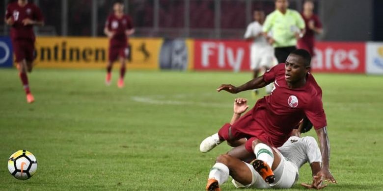 Penyerang timnas U-19 Qatar, Abdulrasheed Umaru, saat berebut bola dengan salah satu pemain timnas U-19 Indonesia pada laga babak penyisihan Grup A Piala Asia U-19 2018 di Stadion Gelora Bung Karno, Minggu (21/10/2018).