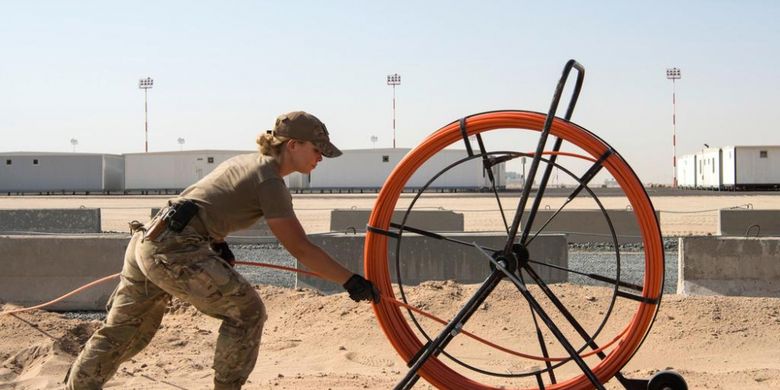 Tentara senior Kelsie Burt mengeluarkan gulungan kabel komunikasi untuk Cargo City yang berlokasi di dekat Bandara Kuwait. Bandara tersebut diklaim bakal menjadi bandara militer terbesar AS di Timur Tengah.