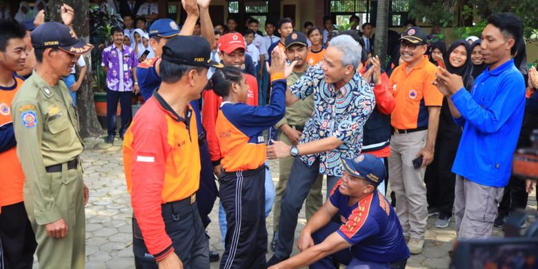 Gubernur Jawa Tengah (Jateng) Ganjar Pranowo mengajari Novensia Anouw, siswa kelas X SMAN 2 Demak ini untuk memadamkan api, Rabu (27/2/2019).