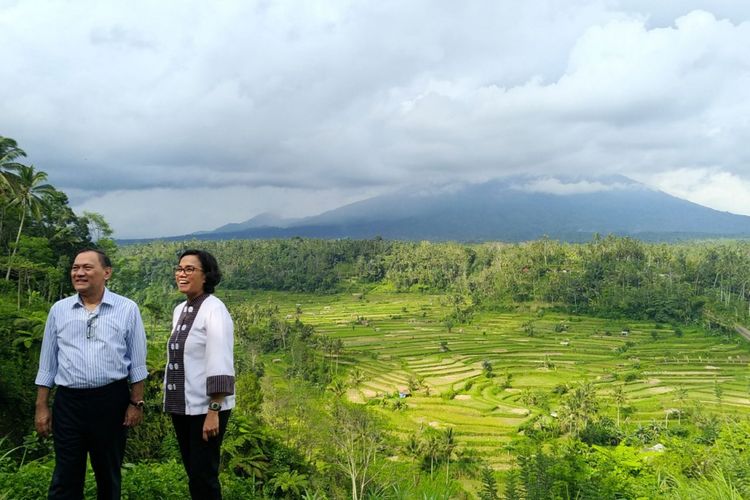 Gubernur BI Agus Martowardojo bersama Menteri Keuangan Sri Mulyani berpose bersama dengan latar belakang Gunung Agung yang tertutup awan di pos pengamatan Gunung Agung di Desa Rendang, Karangasem, Bali, pada Jumat (22/12/2017). 