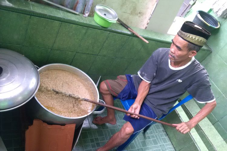 Kartibi juru masak bubur suro, saat mengaduk bubur untuk dibagikan kepada warga dan jamaah masjid Suro Palembang, Sumatera Selatan