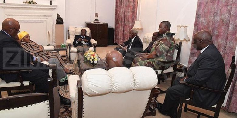 Presiden Zimbabwe Robert Mugabe tengah berbincang dengan panglima tentara dan beberapa utusan dari Afrika Selatan, di Istana Negara, di Harare, Kamis (16/11/2017). (The Herald).