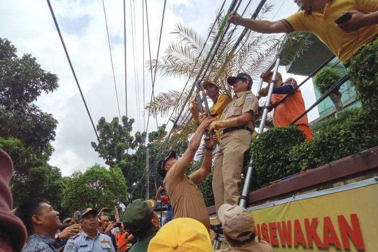 Wali Kota Jakarta Selatan Marullah Matali menggunting kabel utilitas sepanjang 1,4 kilometer di Jalan Warung Jati, Pancoran, Jakarta Selatan, Senin (29/1/2019).