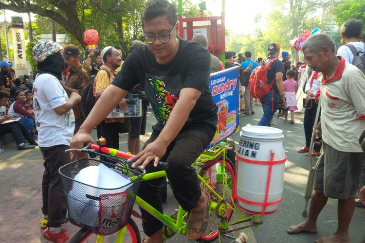 Warga Kelurahan Danukusuman, Aris Joko S bersama prototipe mesin cuci ciptaannya saat dikenalkan kepada warga masyarakat di Jalan Slamet Riyadi Solo, Jawa Tengah, Minggu (30/9/2018).