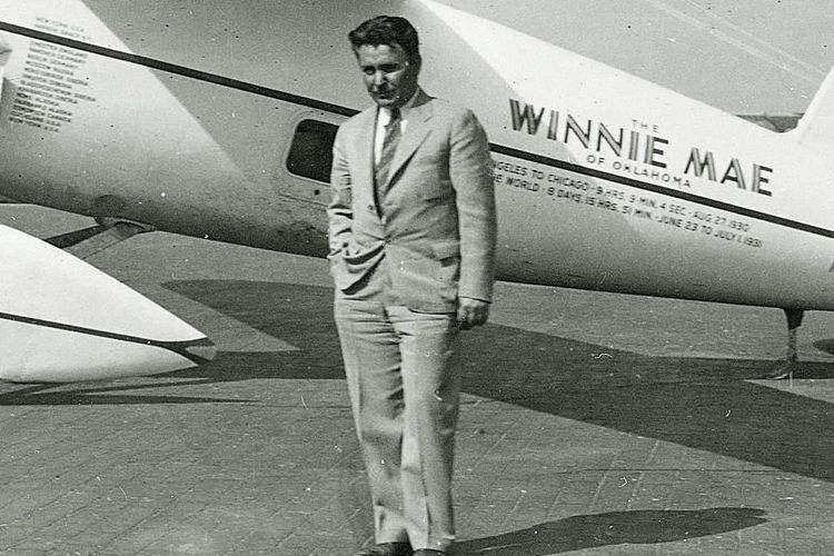 Wiley Post berpose di depan pesawat Winnie Mae. 