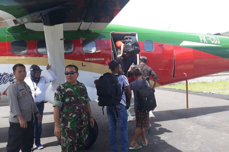 Empat pekerja saat akan naik pesawat dari Bandara Kenyam menuju Timika, Kamis. (13/12/2018)