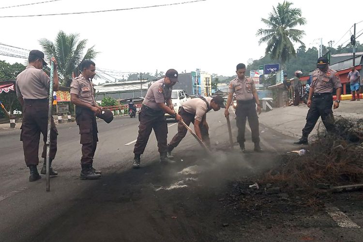 Sejumlah polisi membersihkan sisa kerusuhan di salah satu ruas jalan di Manokwari, Papua Barat, Selasa (20/8/2019). Kondisi Manokwari sudah kondusif dan warga mulai melakukan aktivitas di ruang publik meskipun dalam skala terbatas.