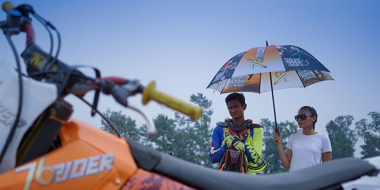 Kroser sekaligus freestyle motocross Zulmi Aristiawan sedang dipayungi umbrella girl di Sirkuit Paramount, Bumi Serpong Damai, Tangerang, Banten, ketika melakukan syuting TVC 76 Rider. 