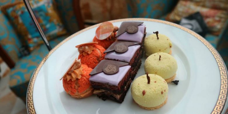 Camilan menemani High Tea di Palazzo Versace Gold Coast. Di bagian tengah kue cokelat bergambar Medusa, lambang dari rumah mode Versace.