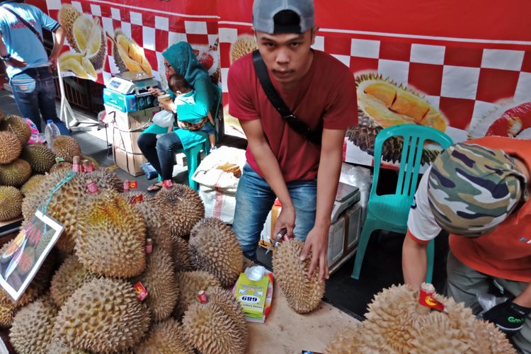 Penjual durian sedang mengupas durian medan, di bazar durian Blok M Square, Jakarta, Rabu (7/2/2018)