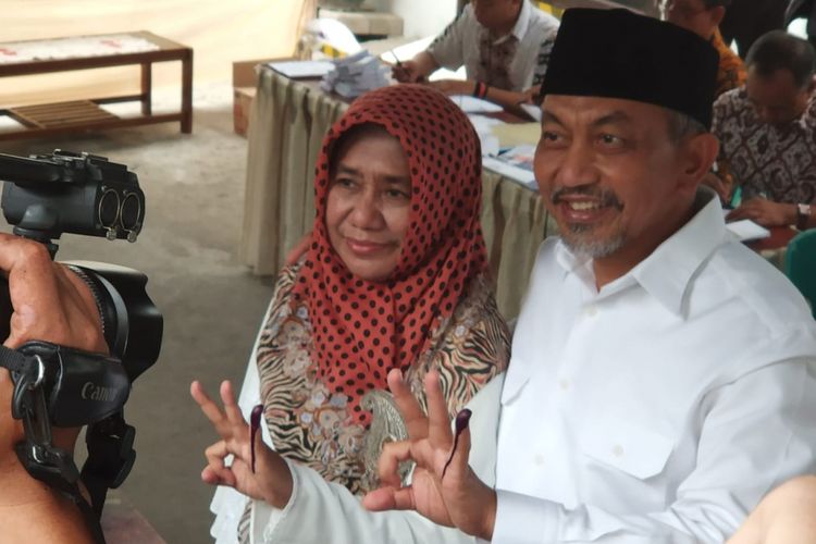 Syaikhu bersama istri menuju TPS 76 di Jalan Antara, Rabu (27/6/2018)