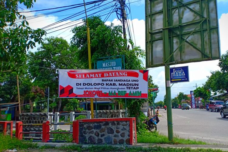 Inilah spanduk berlatar belakang warna putih itu bertuliskan Selamat Datang Bapak Sandiaga Uno di Dolopo, Kabupaten Madiun. Tetapi Mohon Maaf Pilihan Kami Sudah Tetap Jokowi-Maruf terpasang dibeberapa titik saat Sandiaga berkampanye di Kabupaten Madiun dan Kota Madiun. 