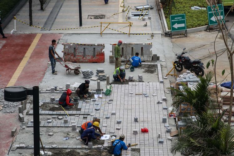 Pekerja menyelesaikan revitalisasi trotoar dan taman di kawasan jalan Sudirman, Jakarta Pusat, Kamis (19/7/2018). Penataan trotoar dan taman ditargetkan selesai pada akhir bulan Juli sebelum pelaksanaan Asian Games 2018.