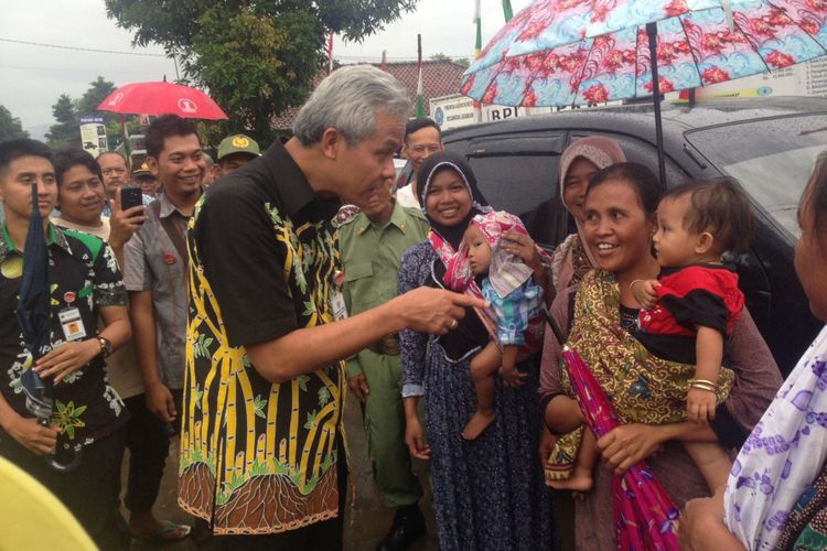Gubernur Jawa Tengah Ganjar Pranowo menyapa balita saat kunjungan kerja di Kabupaten Brebes, Rabu (20/12/2017).