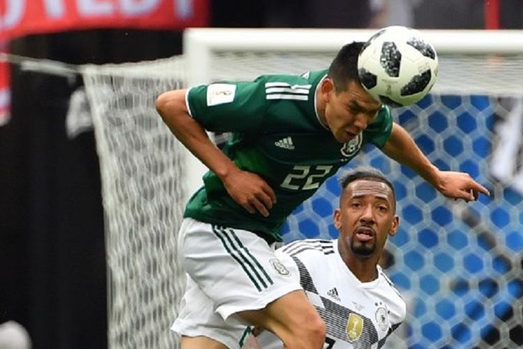 Hirving Lozano menyundul bola saat dibayang-bayangi Jerome Boateng pada laga Jerman vs Meksiko di Stadion Luzhniki, 17 Juni 2018. 