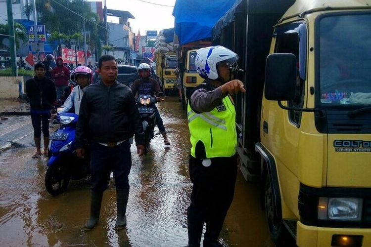 Banjir yang menerjang Kabupaten Bandung menyebabkan arus lalu lintas di empat lokasi lumpuh total, Jumat (23/2/2018).