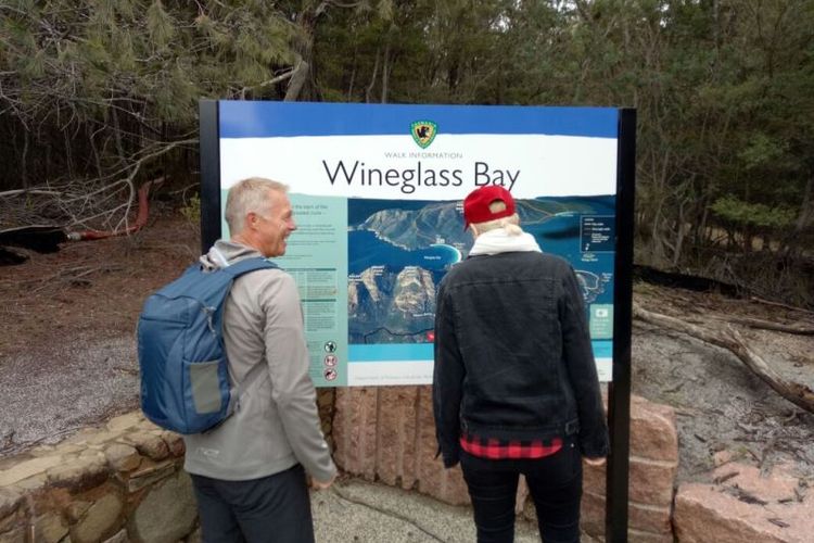 Pengunjung membaca peta rute menuju ke Wineglass Bay Lookout.