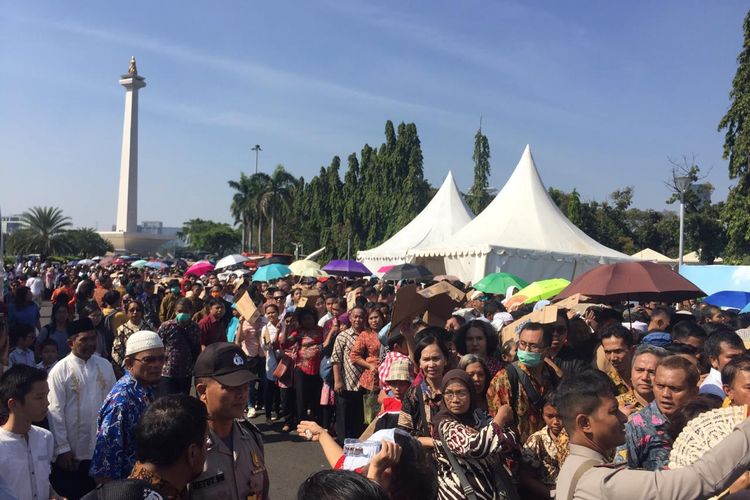 Masyarakat mengantre di pelataran Monas, Jakarta, Rabu (5/6/2019), menunggu giliran masuk ke Istana Negara guna bersilaturahmi dengan Presiden Joko Widodo pada lebaran hari pertama.