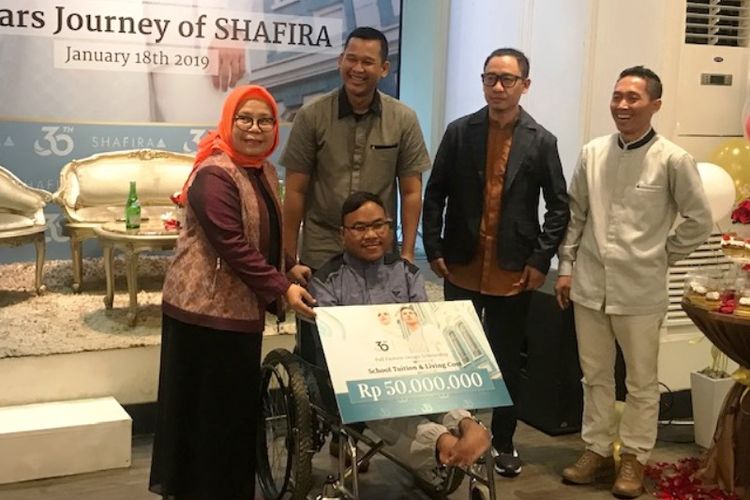 Pendiri Shafira, Feny Mustafa, menyerahkan secara simbolik bantuan beasiswa sekolah mode untuk Rahmat, dalam acara temu media 30 Tahun Shafira di Jakarta (18/1/2019).