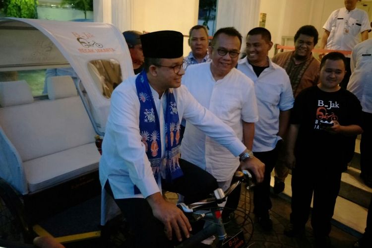 Gubernur DKI Jakarta Anies Baswedan mencoba becak modifikasi yang ditunjukan Wakil Ketua DPRD DKI Jakarta Mohamad Taufik di Balai Kota, Jumat (11/5/2018).  