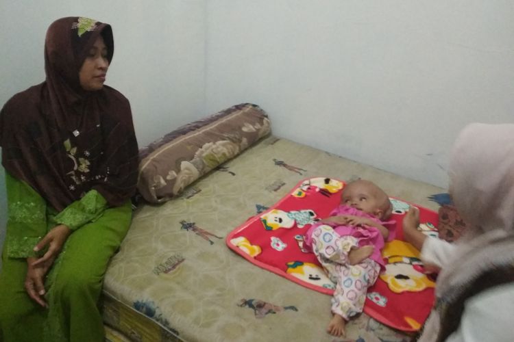 Ibu bayi Evi, Siti Nurhayati (kiri), menceritakan kondisi putrinya yang menderita hidrosefalus.