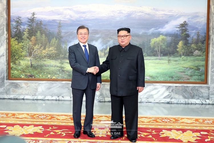 Pemimpin Korea Utara Kim Jong Un (kanan) berjabat tangan dengan Presiden Korea Selatan (Korsel) Moon Jae In di kawasan demiliterisasi Panmunjom pada Sabtu (26/5/2018).