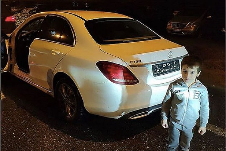 Rakhim Kurayev (5) berpose di depan mobil Mercedes-Benz putih hadiah dari pemimpin Chechnya Ramzan Kadyrov.