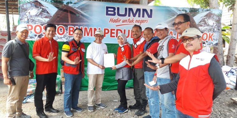 Direktur Consumer Service Telkom Siti Choiriana (kelima dari kiri) menyerahkan simbolis bantuan TelkomGroup kepada perwakilan penerima bantuan di Posko BUMN Peduli, Lombok NTB (8/8).