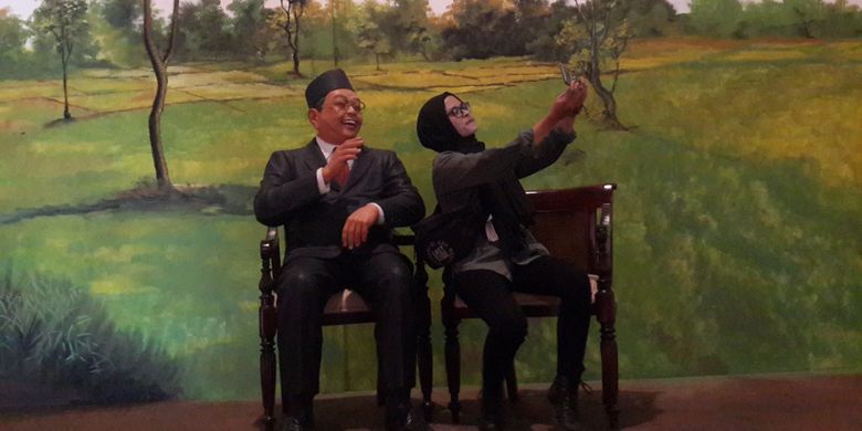 Seorang wisatawan saat berfoto selfi bersama patung Presiden ke-4 RI Abdurrachman Wahid atau Gus Dur di The Legend Star, Jatim Park 3, Kota Batu, Jawa Timur, Jumat (29/12/2017).
