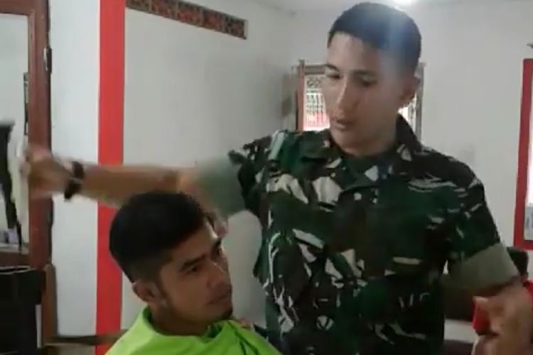 Sertu Anwari, anggota Kodim 0705 Magelang, sedang mencukur rambut pelanggannya, belum lama ini. 